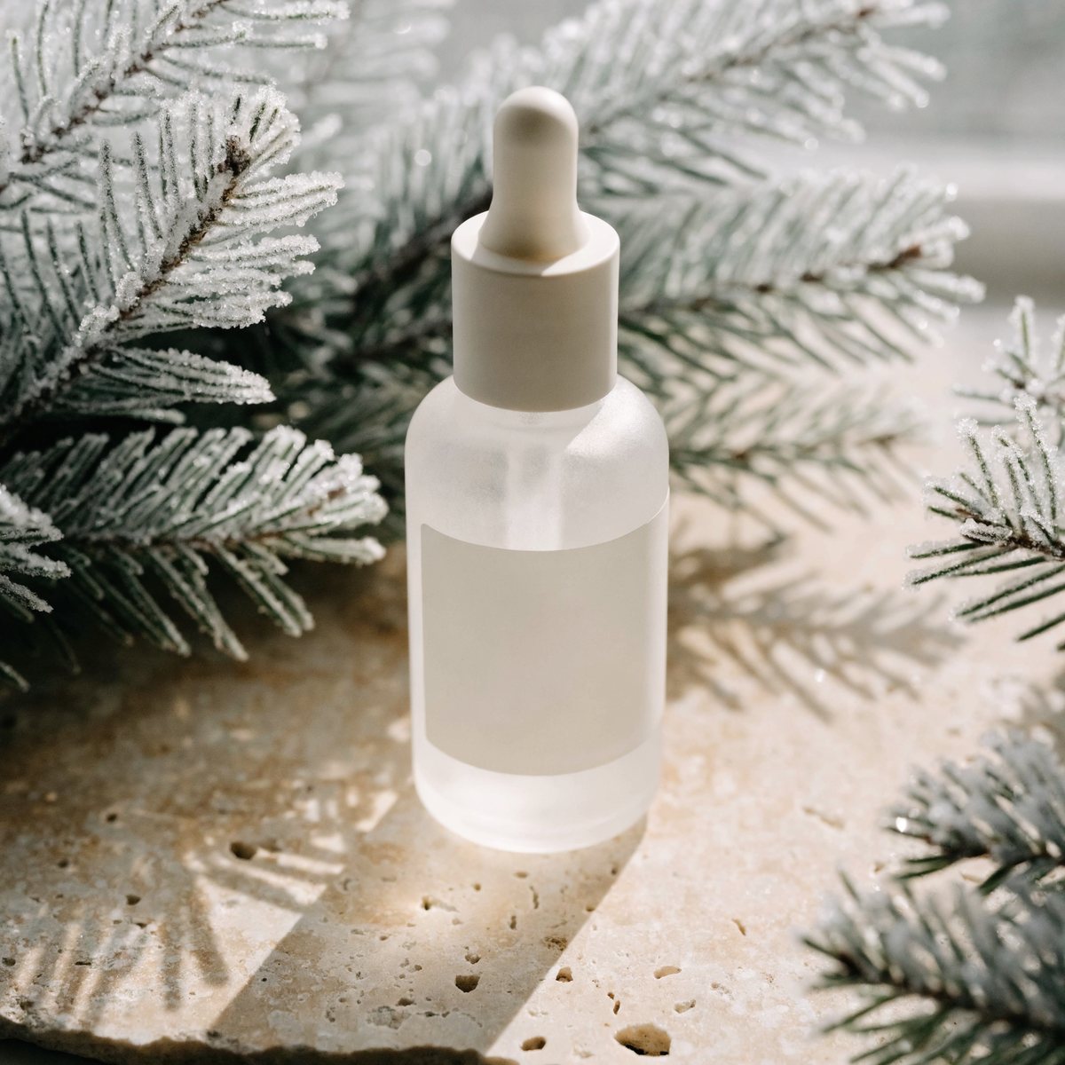 Serum bottle styled for winter with frosted pine